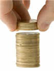 Hand adding a coin to a stack of coins